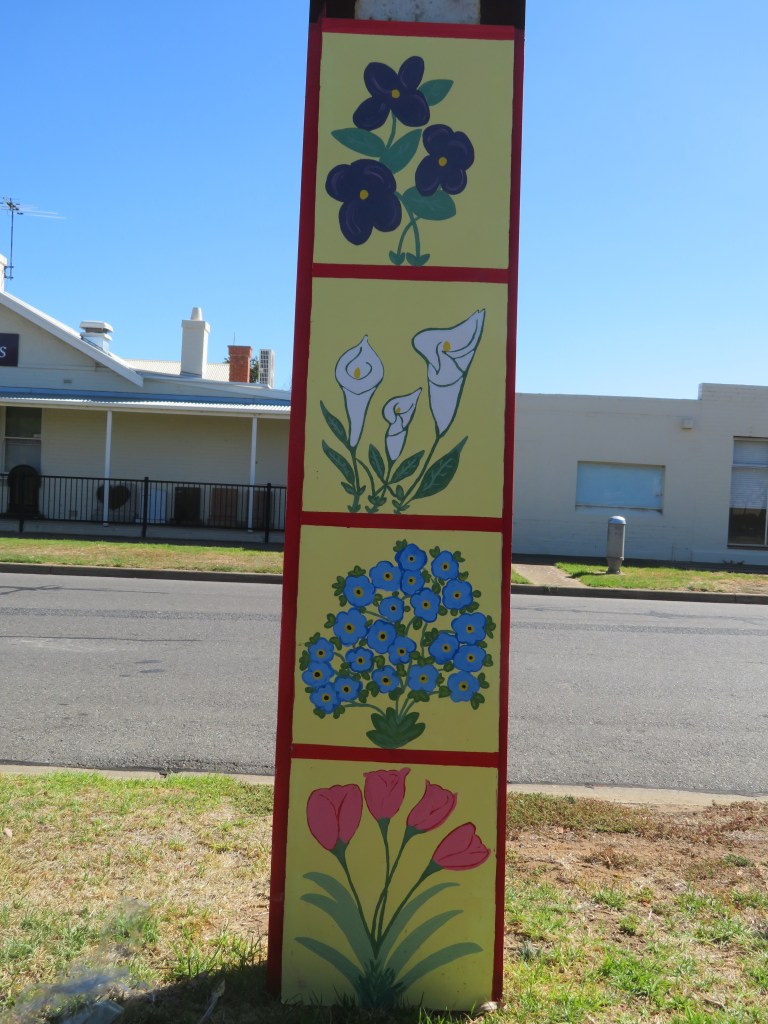 Stobie pole artwork divided into four equal squares, each containing a different floral image on yellow background.